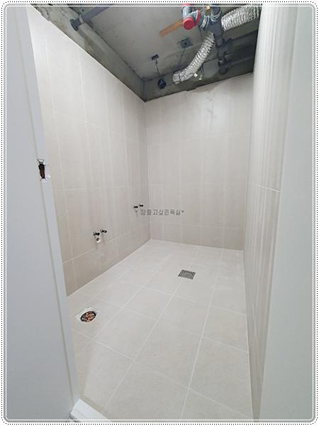 천장 점검구와 환풍기가 보이는 벽 타일 시공 상태
