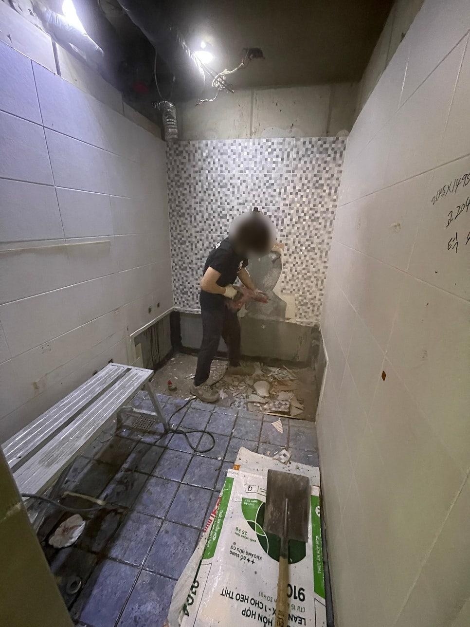 타일 벽면 철거 후 자재 조각들이 놓인 작업 현장