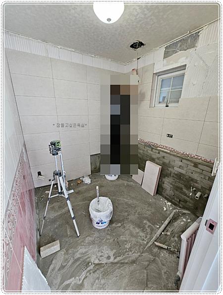 타일 벽면과 바닥 콘크리트가 드러난 작업 현장