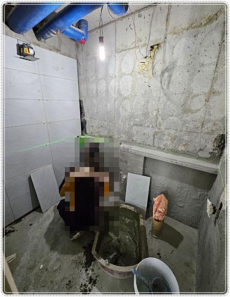 흰색 타일 부착과 함께 자재 통들이 놓인 작업 공간