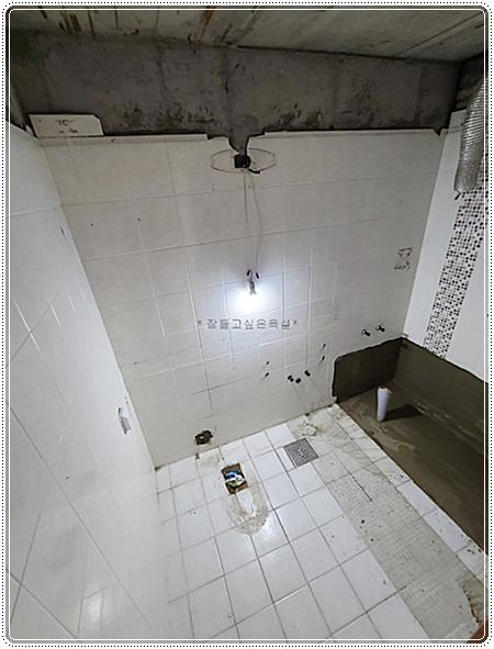 흰색 타일이 시공 중인 욕실 내부 모습