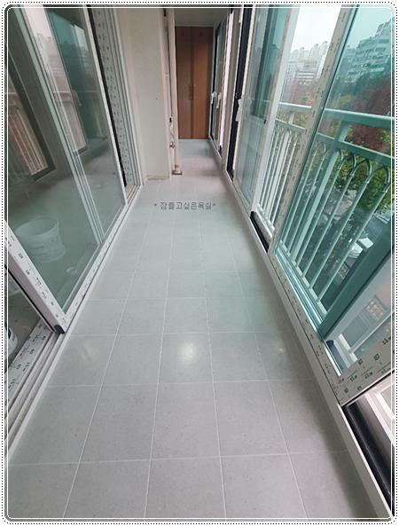 푸른색 난간과 흰색 통이 놓인 베란다 시공 현장