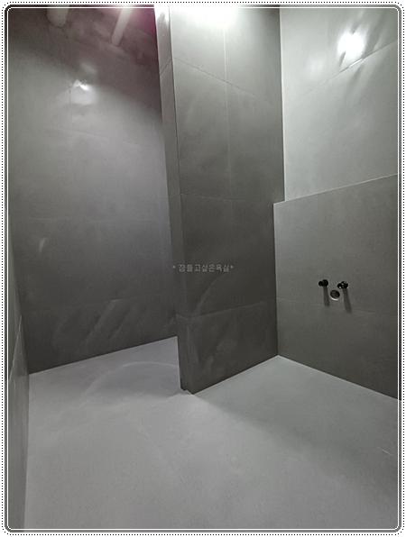 그레이톤 타일과 샤워 설비가 보이는 시공 중 모습