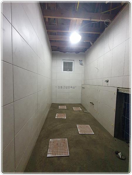 흰색 타일 벽면과 천장 구조물이 보이는 작업 현장