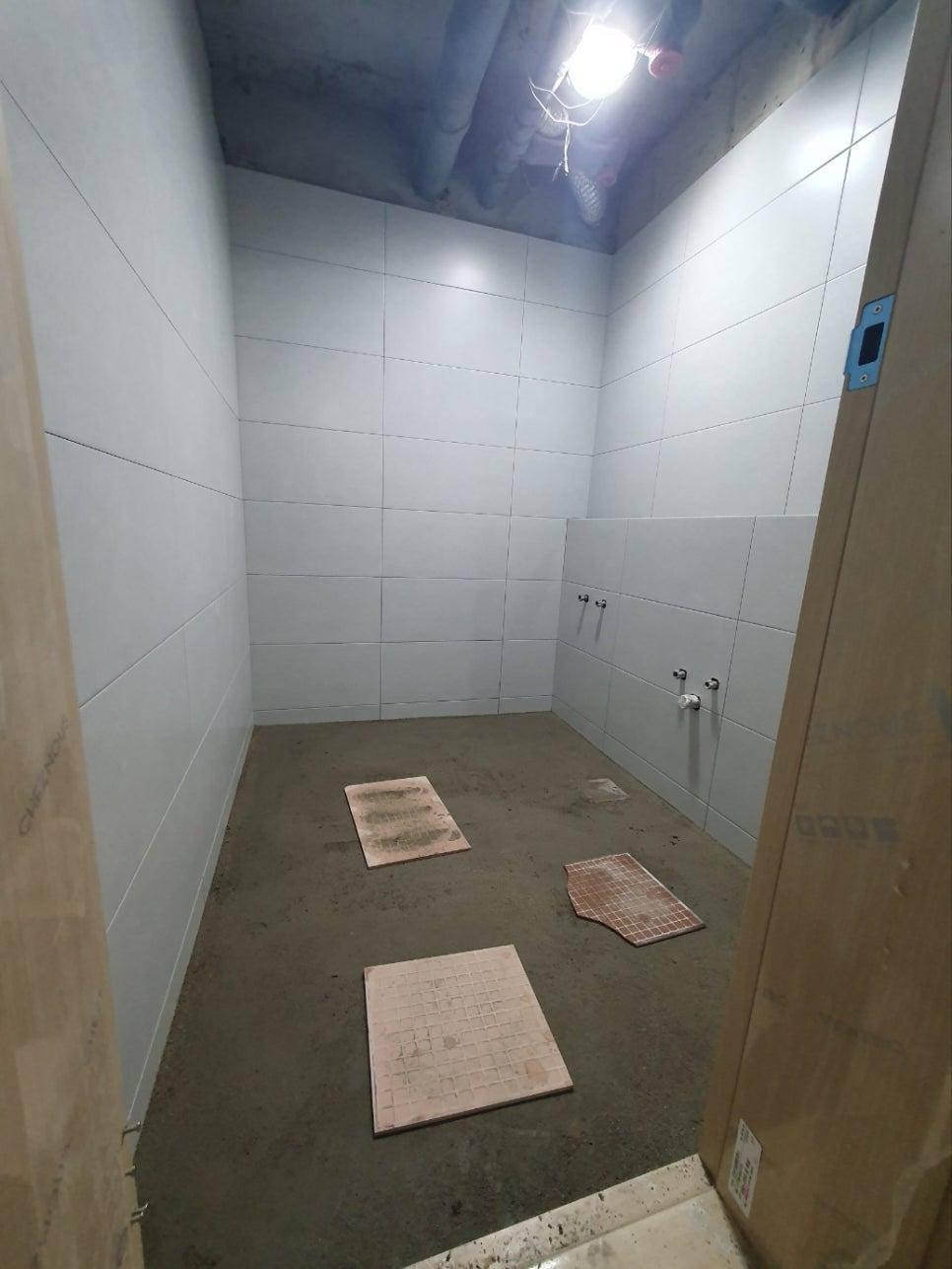 천장 파이프가 노출된 상태의 타일 시공 전경입니다