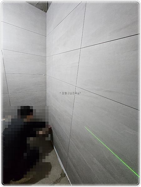 레이저 라인으로 수평을 맞추며 타일을 부착하는 모습