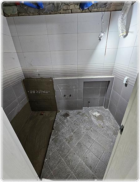 레이저 수평을 맞추어 시공 중인 벽 타일