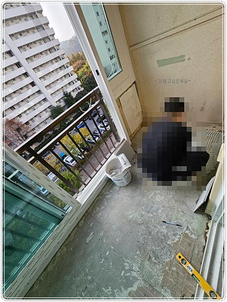 레벨기와 펜을 두고 수평을 확인 중인 발코니 바닥