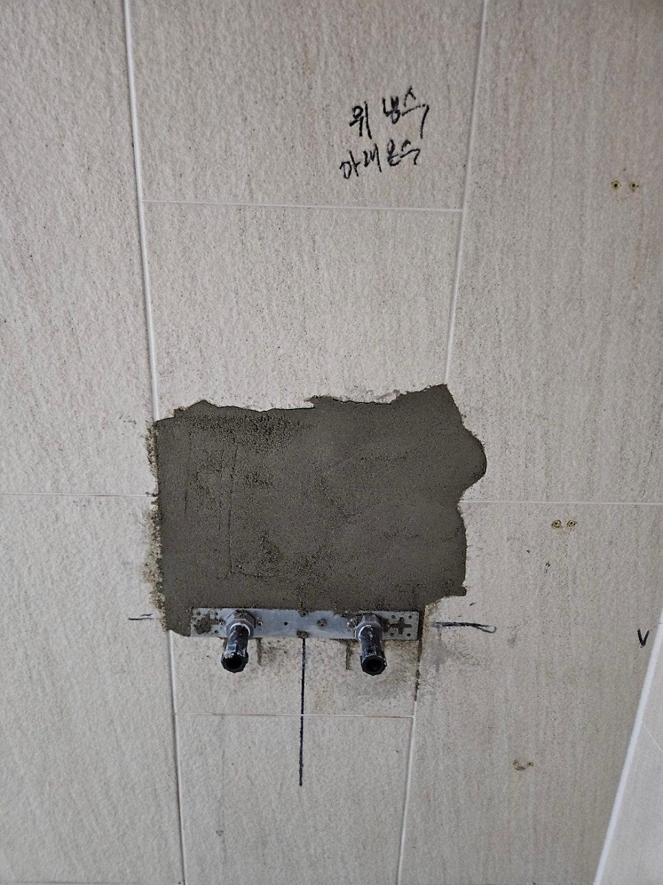 매립 수전을 노출 수전으로 변경하기 위한 설비 작업 중인 벽면