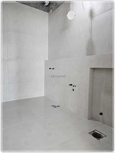 흰색 타일로 마감된 벽과 바닥의 시공 상태