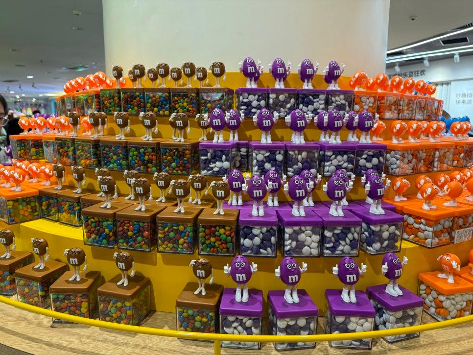 M&M 캐릭터 인형과 컬러풀한 사탕 진열