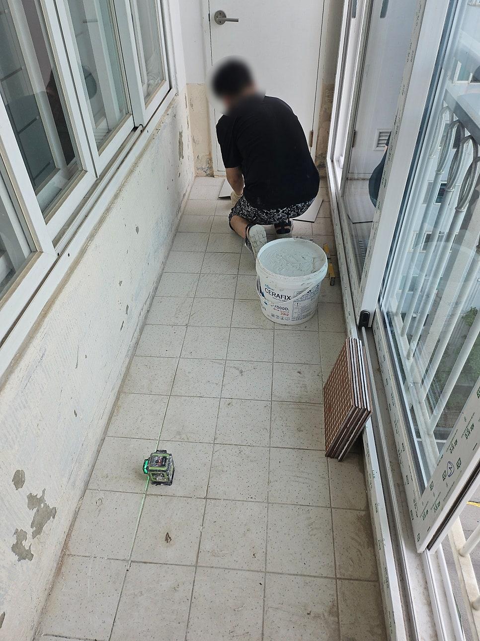 흰색 타일 바닥과 벽면에 흠집이 있는 기존 발코니 모습