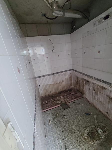벽 타일과 설비 배관이 드러난 철거 과정