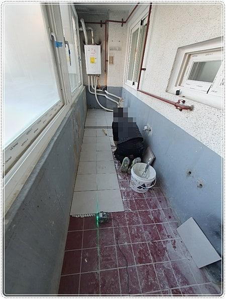 파란색 보호층의 벽과 붉은 타일 바닥이 보이는 시공 전 모습
