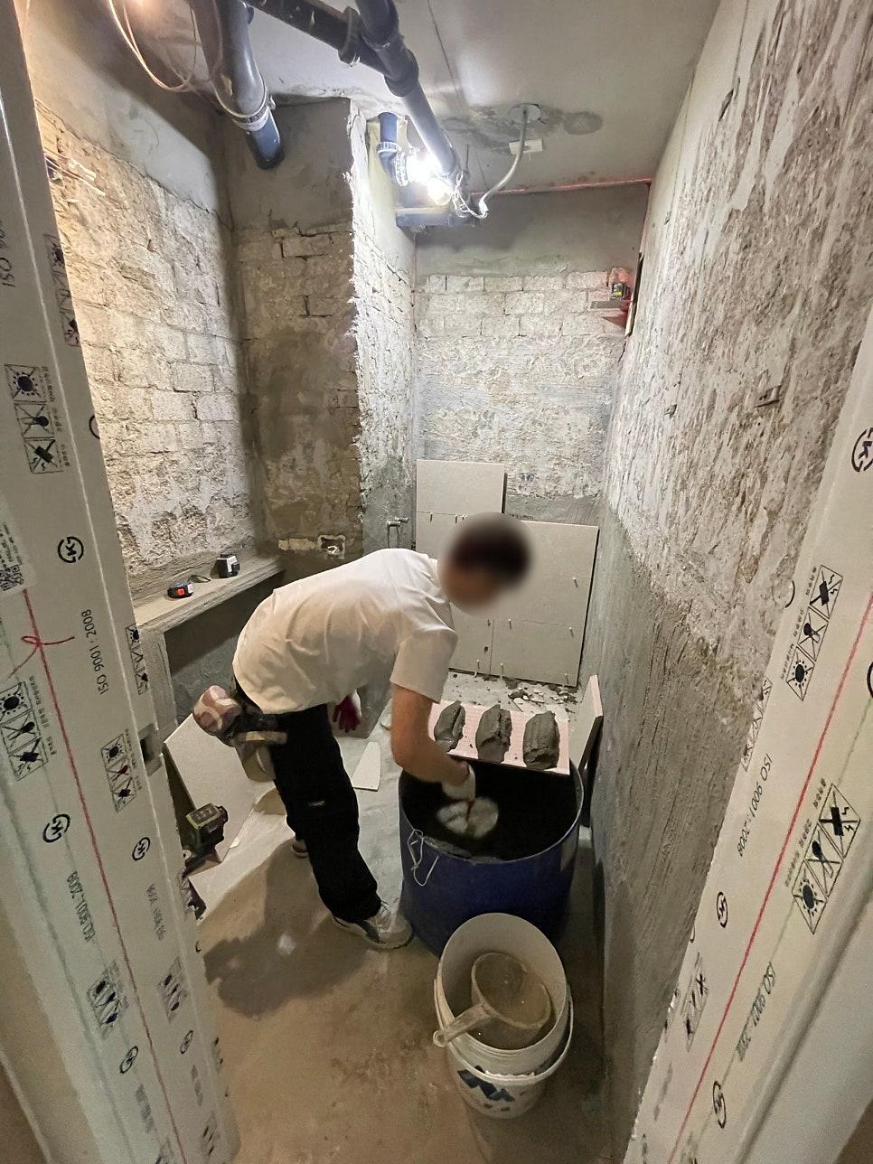 벽면 정리를 진행 중인 작업자와 노출된 콘크리트 벽