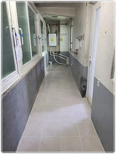회색 타일 바닥과 무채색 벽면이 조성된 내부