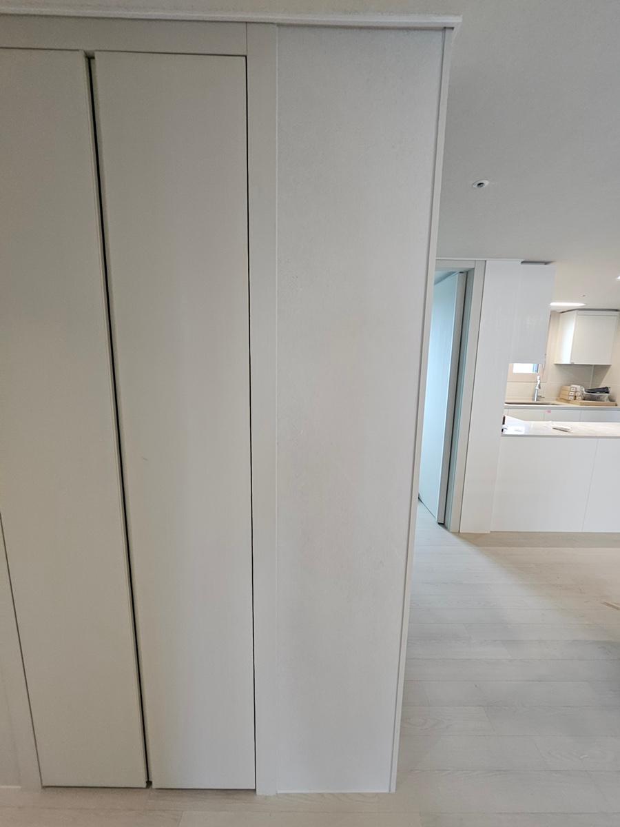 흰색 슬라이딩 도어와 수납장이 있는 드레스룸