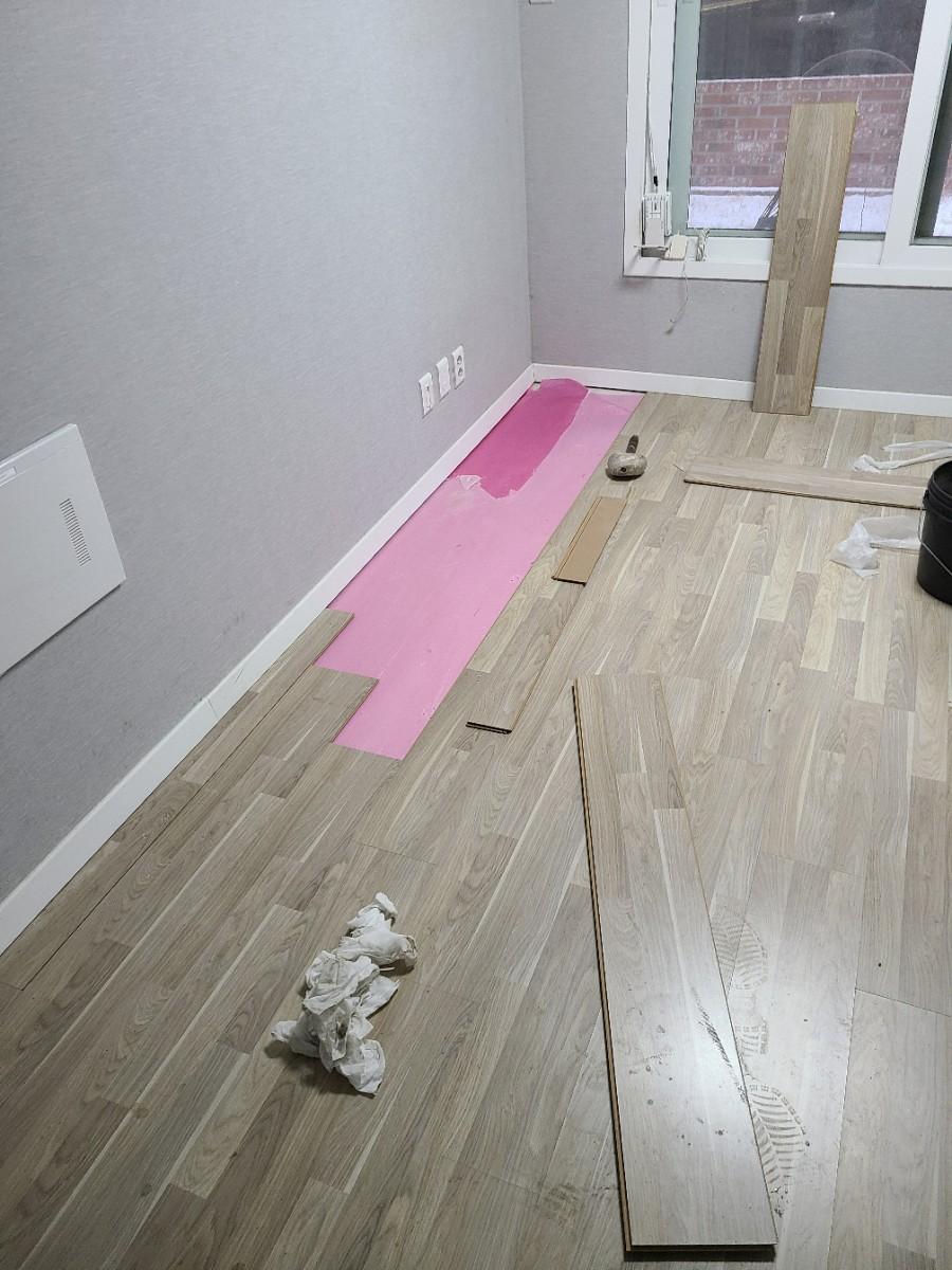 흰색 베이스보드와 나무 바닥재가 놓인 작업 공간