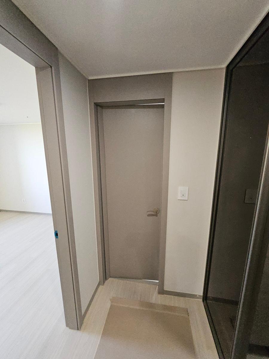회색 벽면과 흰색 바닥재로 마감된 복도