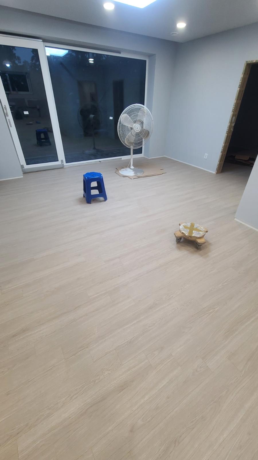 회색 벽면과 목재 패턴 바닥이 적용된 실내