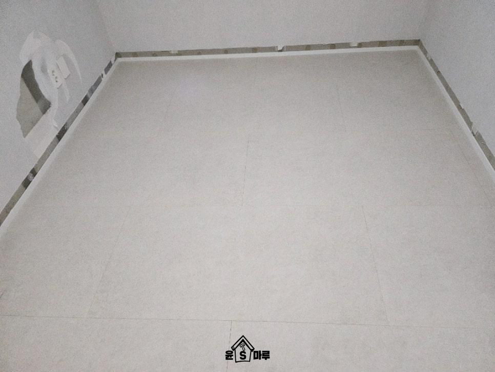 흰색 타일 바닥과 벽면 경계의 금색 테두리
