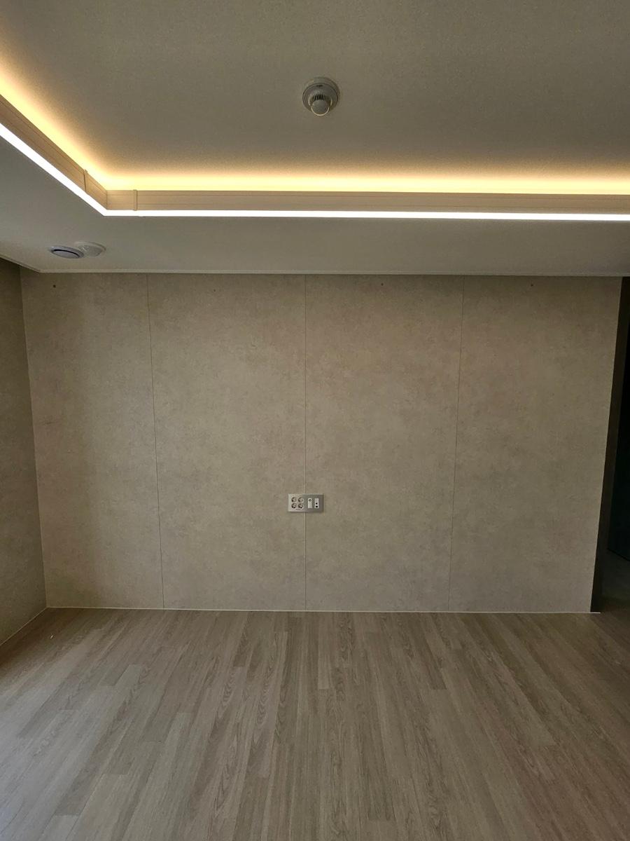 회색 벽면과 목재 바닥의 정갈한 빈 공간