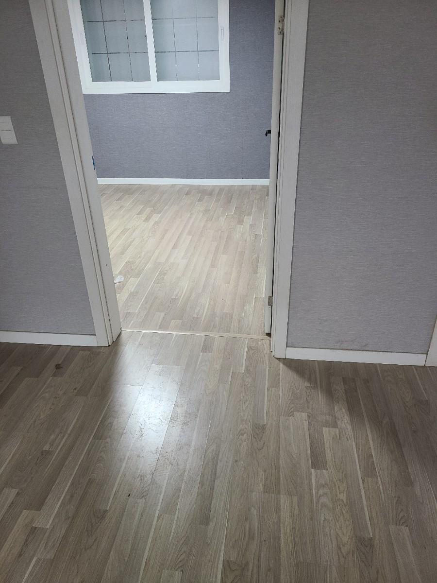 회색 벽지와 목재 바닥재가 만나는 마감면
