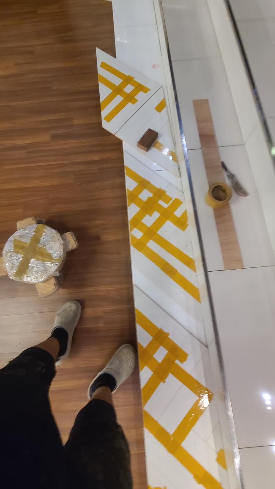 격자 테이프로 기준선을 잡은 타일 바닥