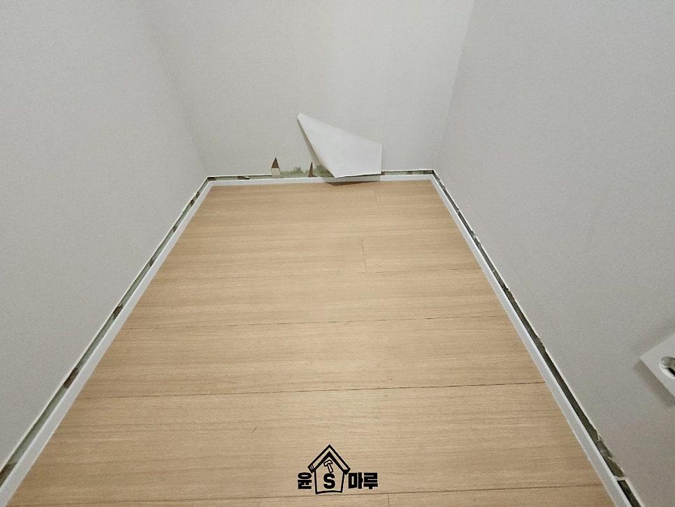 흰 벽과 베이지색 바닥재가 있는 좁은 복도