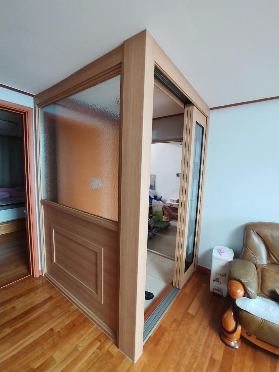 흰색 벽지와 목재 마루가 만나는 중문 프레임