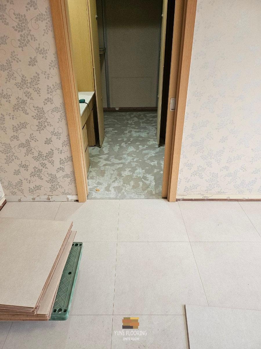 벽지와 문이 설치된 복도의 바닥 시공 과정