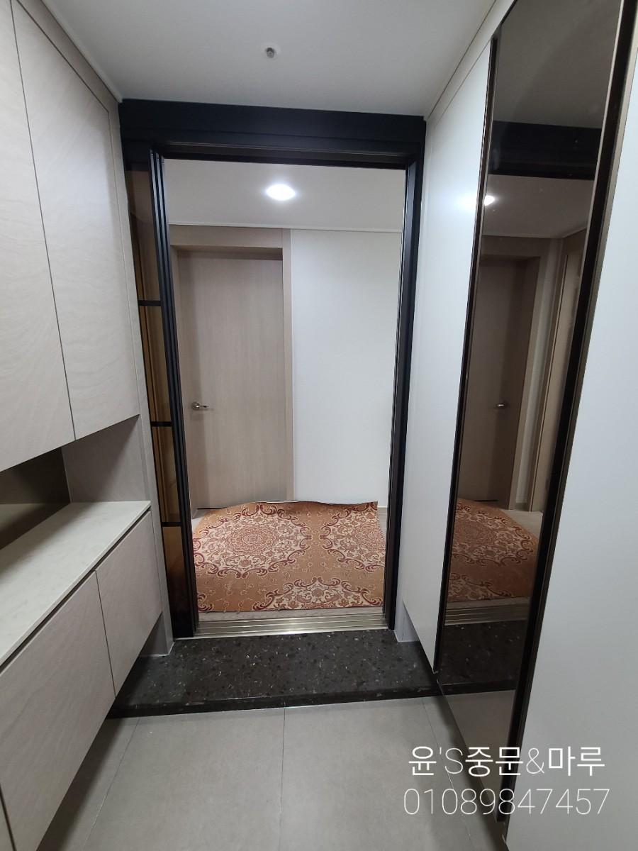 어두운 우드톤 도어와 베이직 타일 바닥이 보이는 실내