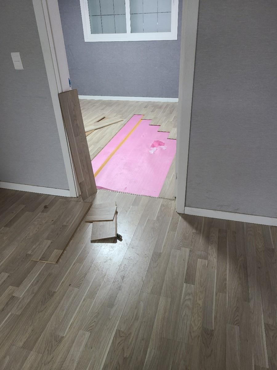 문 옆 나무 패널과 함께 보이는 마루 철거 과정