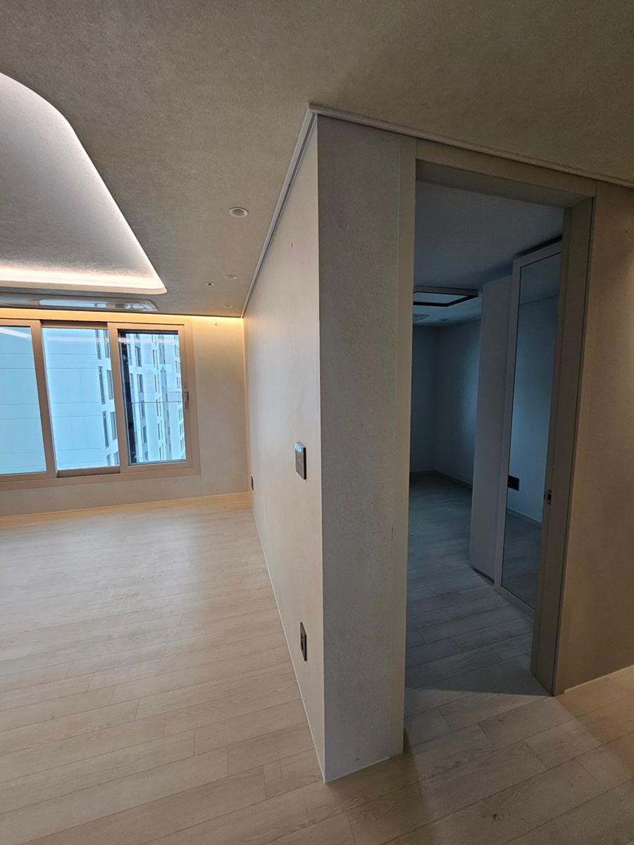 창문 근처 흰 벽과 목재 바닥이 보이는 거실 과정샷