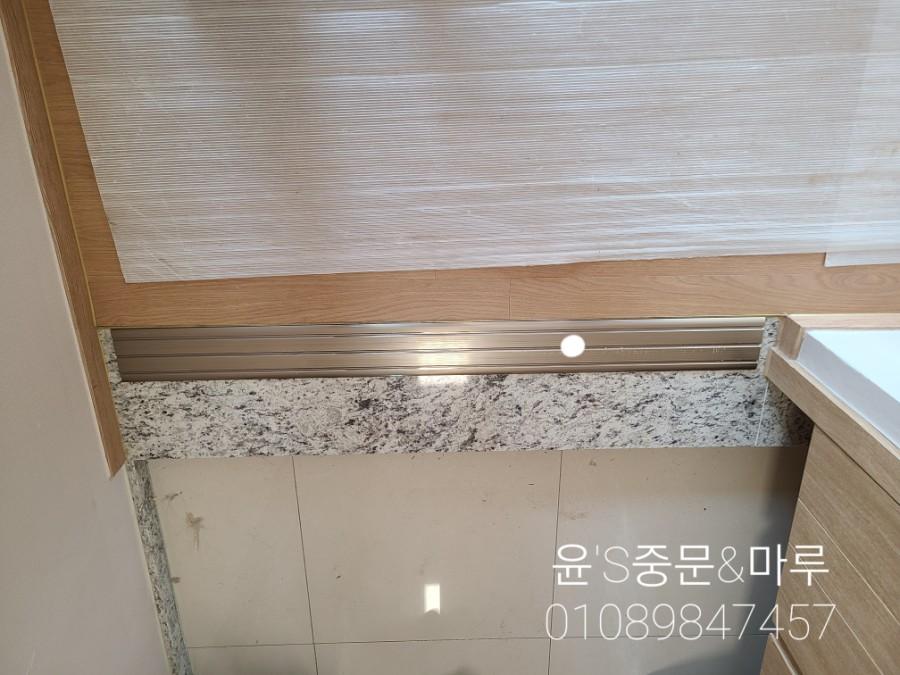 회색 석재 마감과 금속 라인 조명이 어우러진 디테일