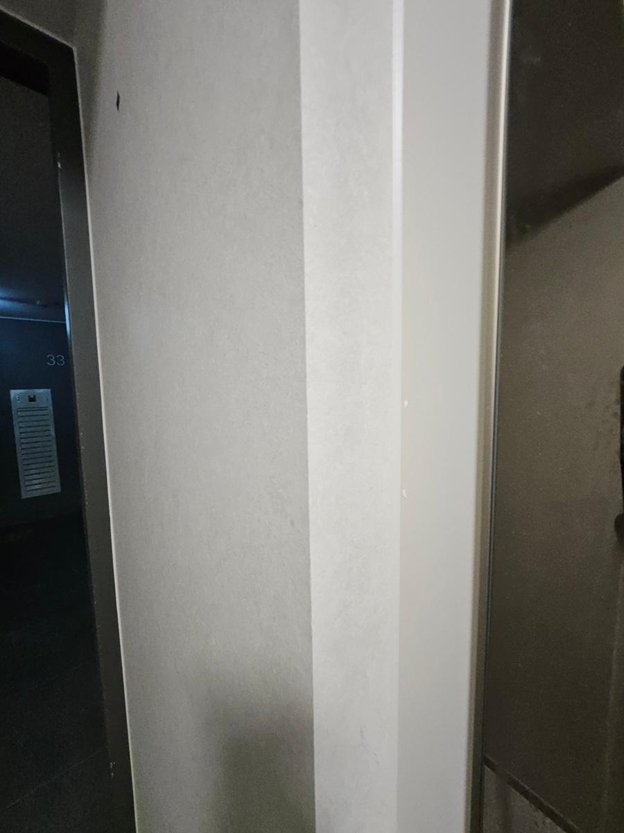 흰 벽면에 세로 보드가 설치된 복도 과정샷