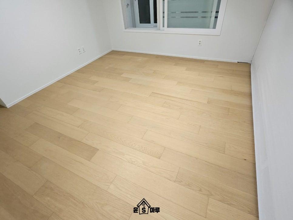 창문과 전기 소켓이 있는 방의 목재 바닥 마감 상태