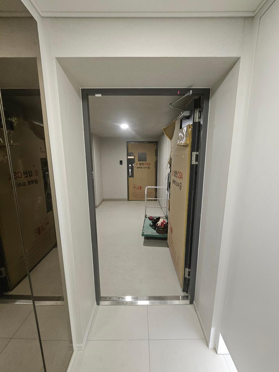 흰 벽과 타일 바닥이 보이는 복도 마감 과정