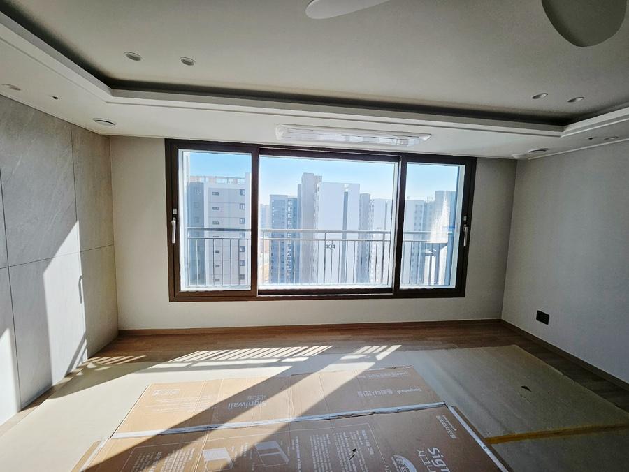 베이지색 벽면과 큰 유리창이 있는 거실
