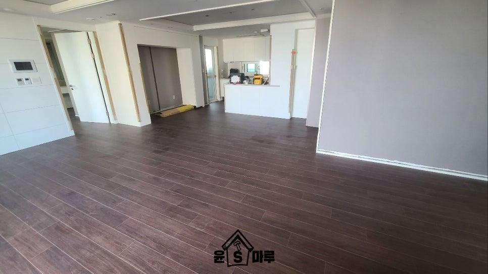 어두운 갈색 바닥재가 깔린 거실 전경