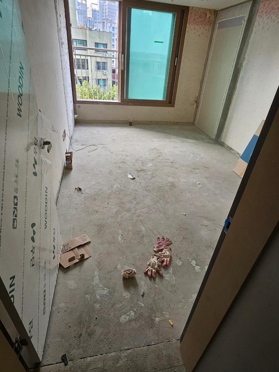 콘크리트 바닥과 부분 도배가 된 방 내부