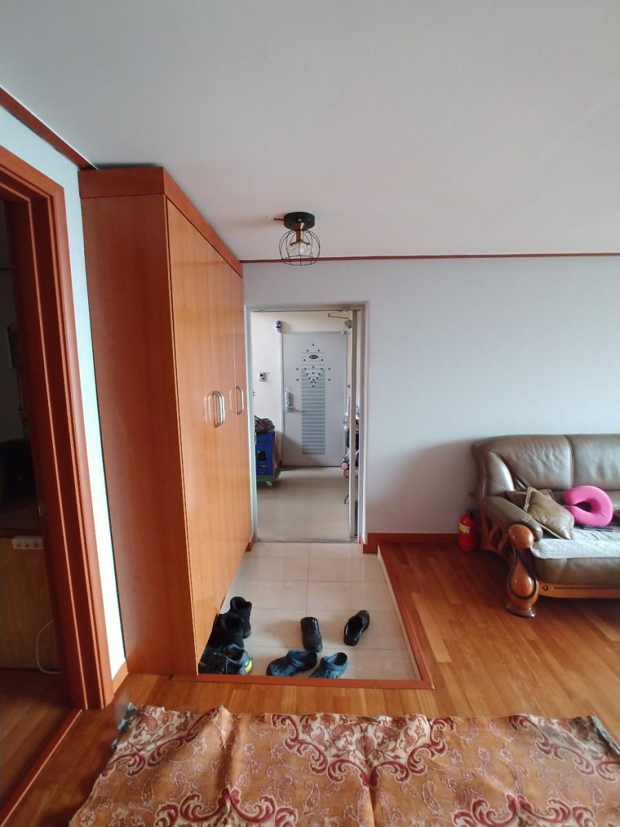 목재 수납장과 가죽 소파가 배치된 진입 공간