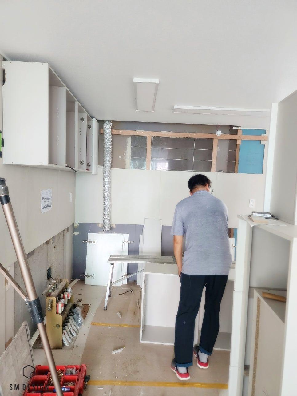 수납장 설치와 조명 작업이 진행 중인 실내