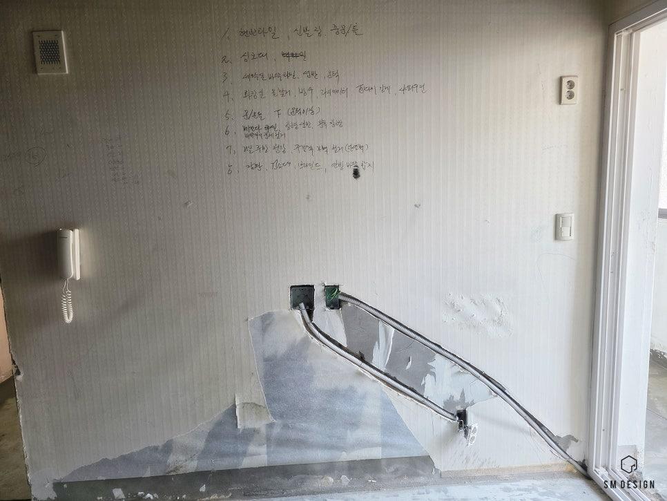 전선이 노출된 흰 벽면의 소켓 부분