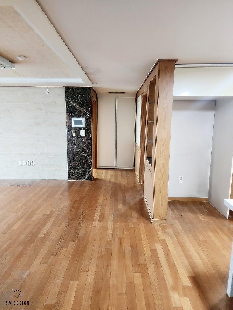 우드톤 수납장과 블랙 대리석 패널이 있는 복도
