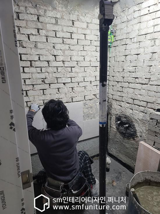 벽면 마감을 위한 도구 사용 모습