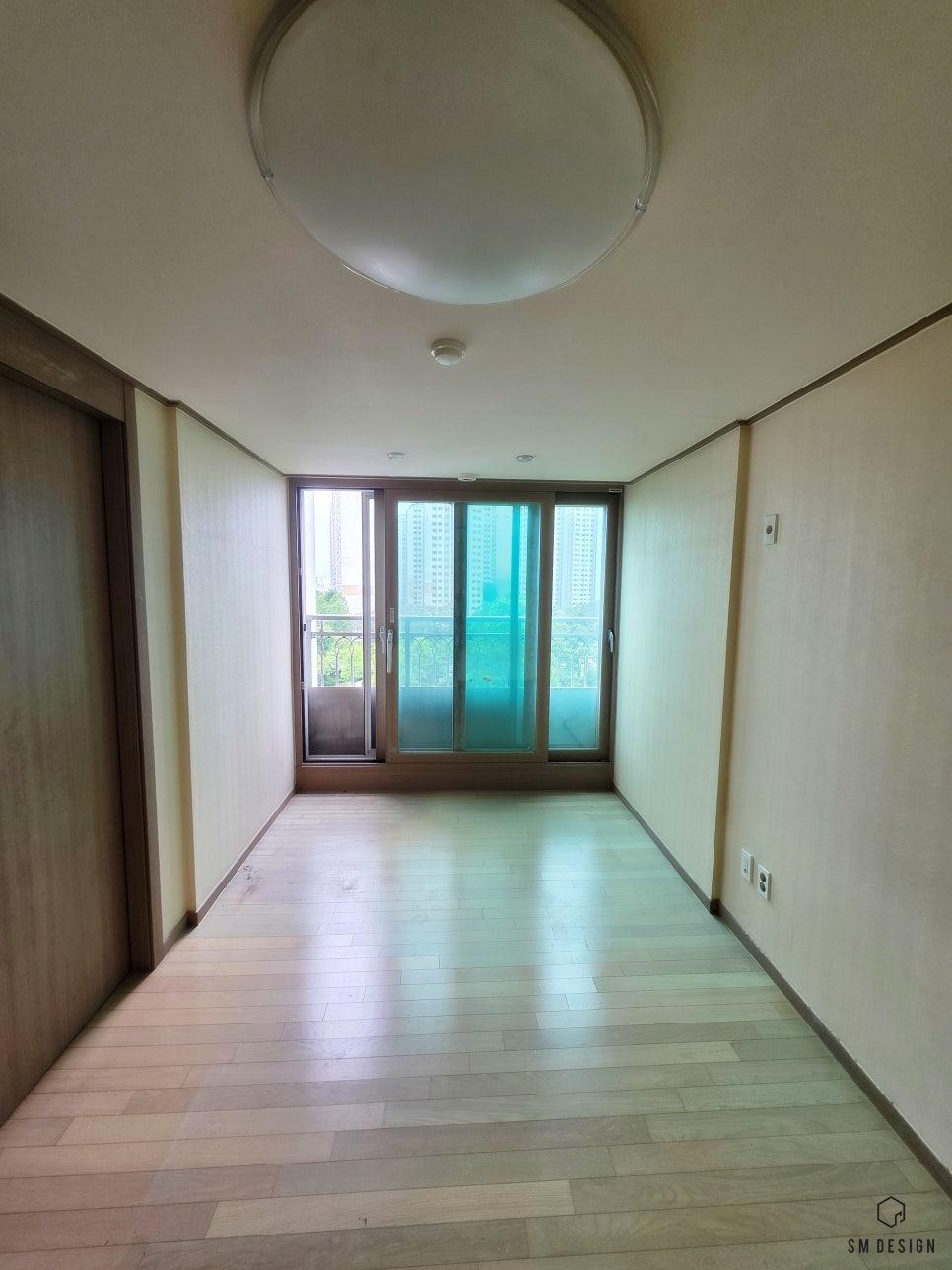 베이지색 벽과 목재 마루가 깔린 시공 전 복도