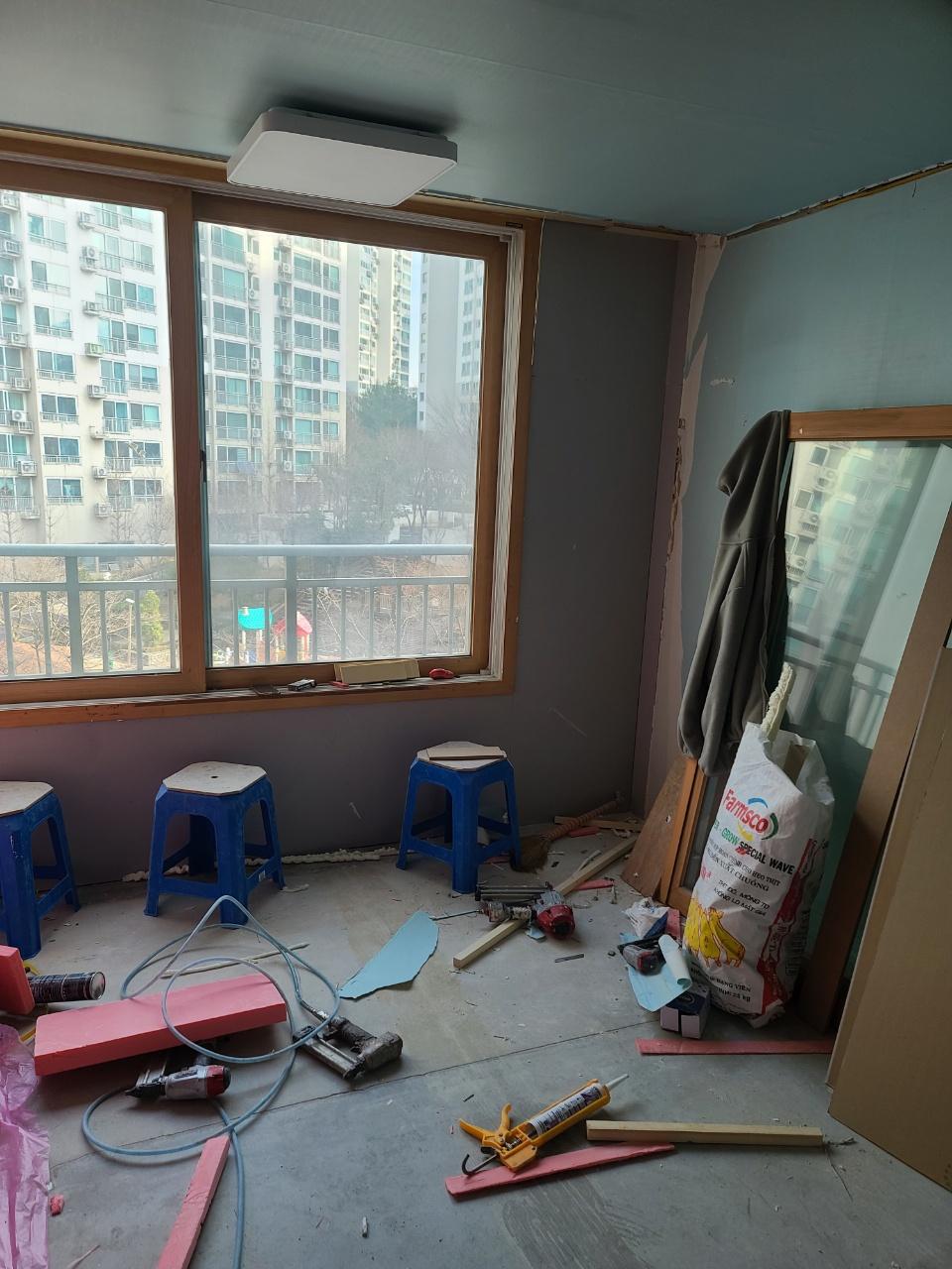창호 주변의 접착제 카트리지와 작업 도구들