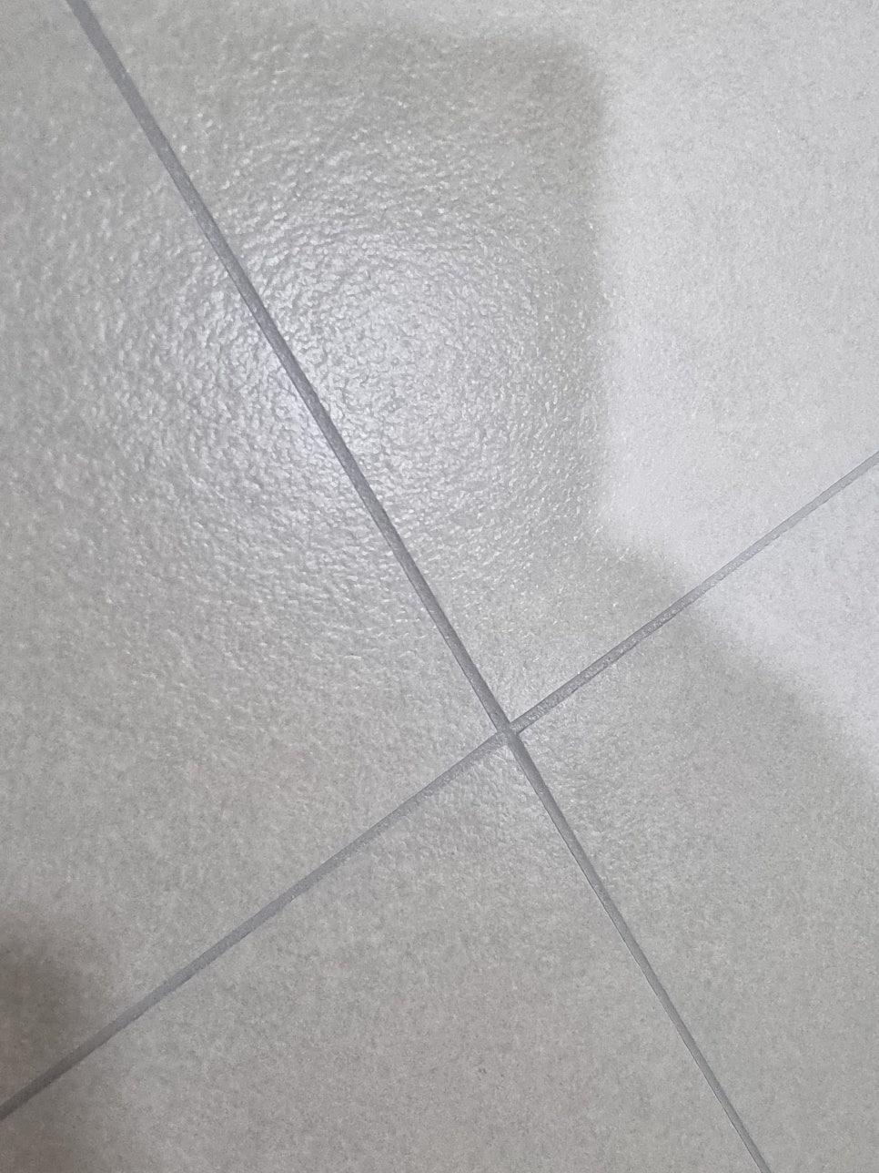 회색 타일 바닥 위 흰색 세라믹 타일 접합선