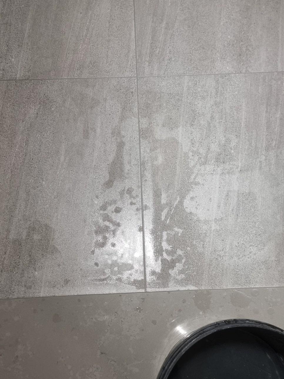 얼룩이 보이는 회색 타일 바닥의 일부